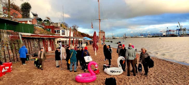 Gruppe von Menschen finden sich nahe des Hamburger Hafens zum Kaltschwimmen ein.