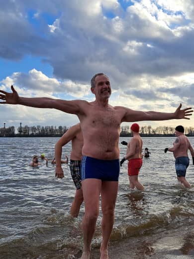 Mann kommt freudestrahlend aus dem kaltem Wasser