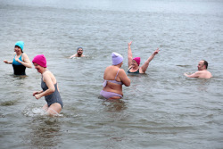 euphorische Frauen mit Eisbademeisters-Mützen und zwei Schwimmern in der Elbe