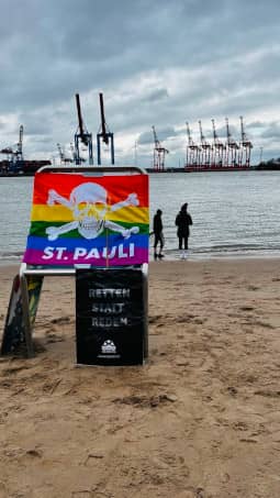 Flagge vom St. Pauli und Sea-Watch Plakat mit Aufschrift Retten statt Reden