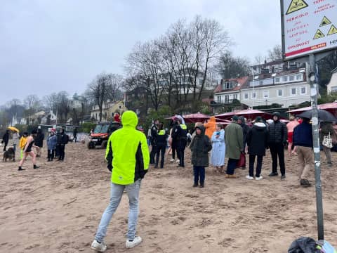 Menschen bei Regen am Elbstrand Höhe Strandperle in Hamburg