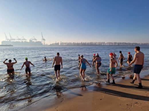Badene mit Mütze und Hanschuhe planschen bei frostigen Temperaturen