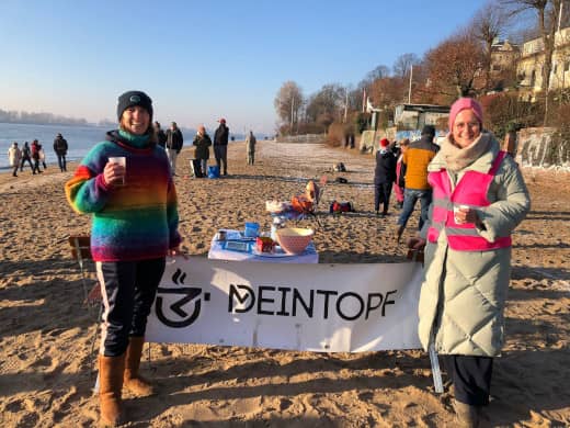 zwei Frauen halten einen Banner mit der Aufschrift deinTopf