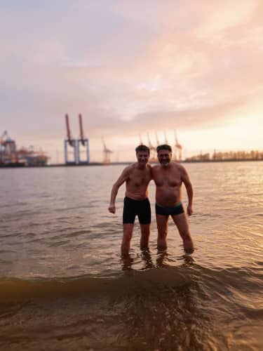 Männer knöcheltief im kalten Flusswasser