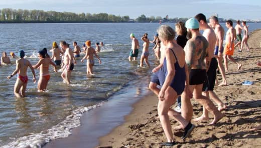 Leute gehen im Herbst in die Elbe baden