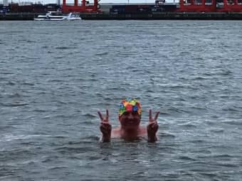 Mann mit bunter Badekappa bis zu den Schultern im eisigen Elbwasser