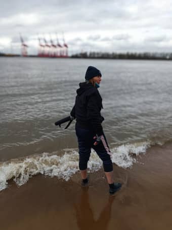 Frau misst Wassertemperatur