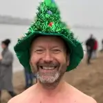 Mann mit grünen Hut beschmückt mit Weihnachtsschmuck