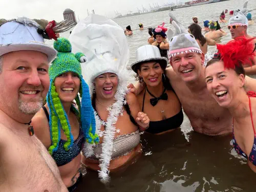 Gruppe von Menschen im Wasser mit kreativer Kopfbedeckung