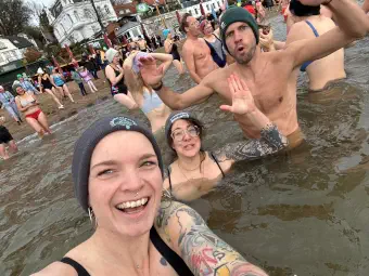 Selfi von drei Menschen, die im kalten Wasser ausharren.