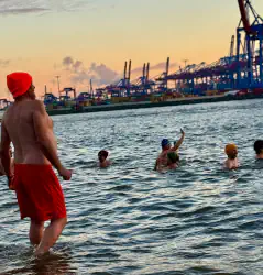 Eisbader wagt sich ins Wasser zu einer Gruppe, die bereits in der Elbe badet.