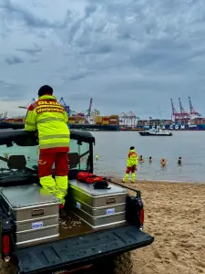 Rettungssanitäter beobachtet Eisbader in der Elbe