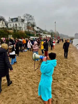 Frau in Bademantel spricht mit Megaphone zu Eisbademeisters-Hamburg
