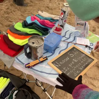 Tisch mit Mützen, Klingelbüchse und Hinweis zur Wassertemperatur (5,6 Grad)