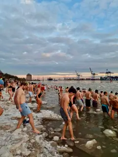 Menschen springen in die kalten Fluten für die Teestube Sarah