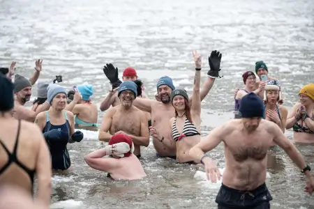 ehrenamtliche Mitarbeiter vom Gabenzaun sowie andere Leute nehmen sind in der Elbe umzingelt von Eisschollen.