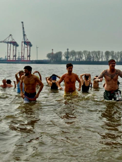 junge Männer sind bis zur Hüfte im eisigen Wasser.
