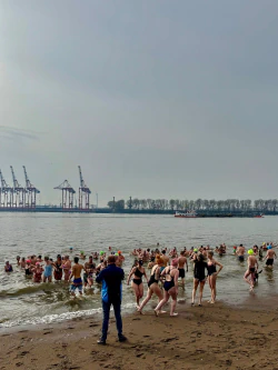 Menschen tummeln im kalten Wasser, um spenden für den Kältebus zu generieren.