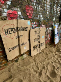 Plakate stehen an einer Mauer